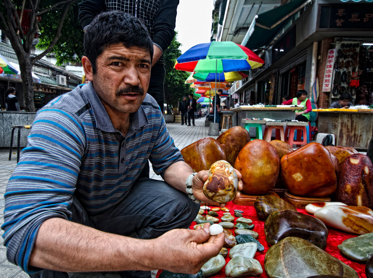 A Uighur man showing what looks like Chinese nephrite jade in Guangzhou's Hualin Street jade market. From Lotus Gemology.
