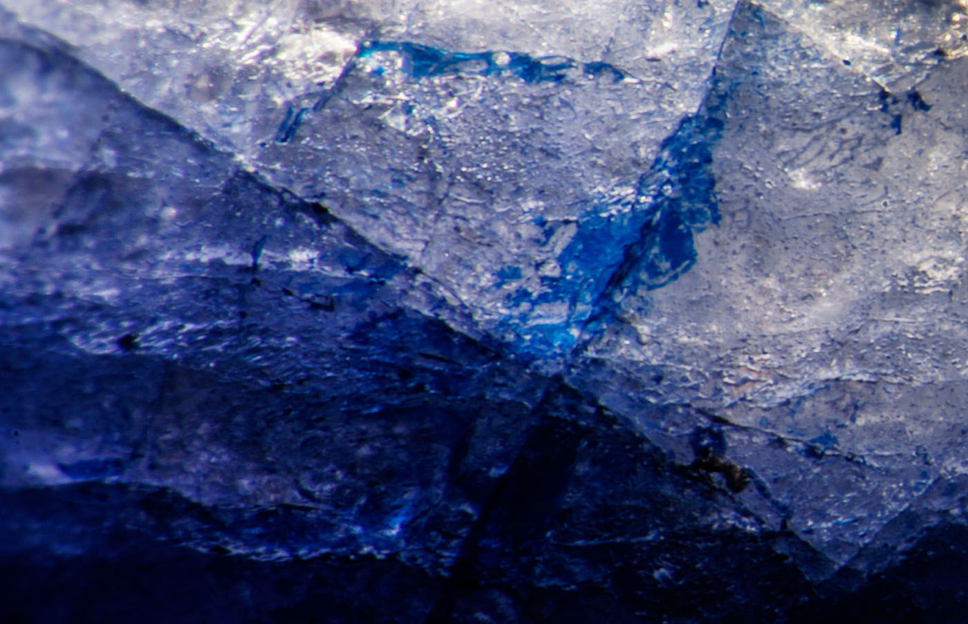 Figure 6. Blue cobalt-doped glass fills a surface-reaching fissure in this first-generation stone. Oblique fiber-optic illumination. (Photo: Wimon Manorotkul, Lotus Gemology).