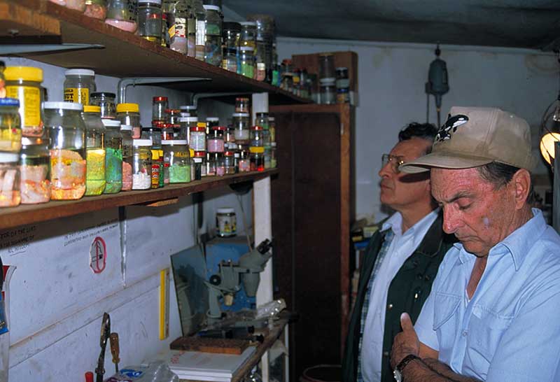 Lenny Cram (far right) and Terry Coldham in Lenny Cram's shed outside his house in Lightning Ridge, Australia.