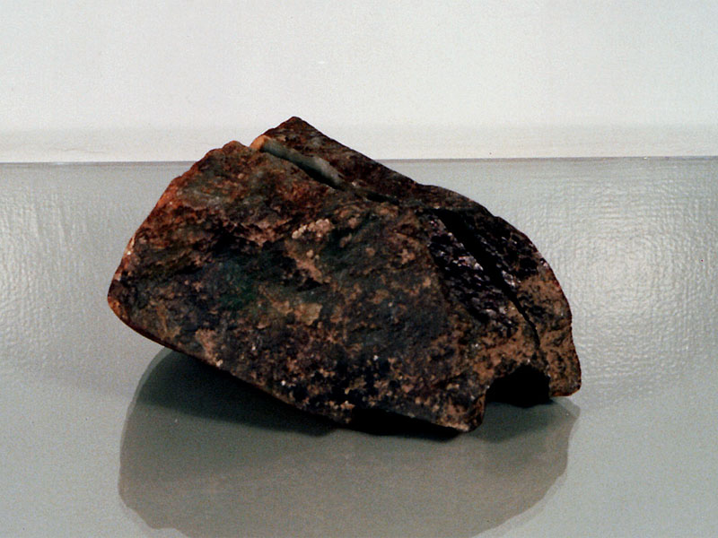 Figure 35. This jadeite boulder had a hole drilled in it from one side to just beneath the surface on the opposite side. A green glue was placed inside near the surface, with a wooden rod added. Then the drill hole was carefully concealed to hide the evidence. Thus when a strong light was shone onto the boulder's surface, a rich green color was revealed. Photos: Richard W. Hughes