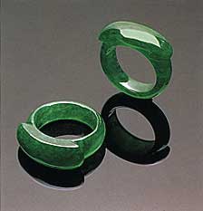 Figure 28. Note the small patches of a slightly paler color on the shank of one of these "emerald" green saddle rings (21.27 and 21.65 mm, respectively, in longest dimension). Photo courtesy of and © Christie's Hong Kong and Tino Hammid.