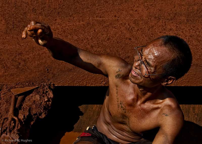One of the last remaining sapphire miners at Khao Ploi Waen examines a find