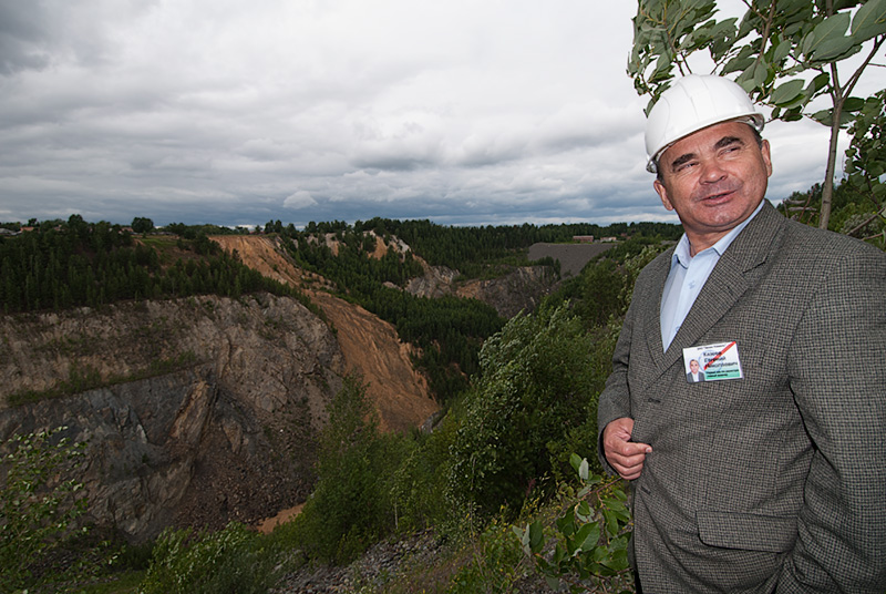 Top: The small village of Malysheva, perches on the very edge of the large open trench (just beyond the trees in the background). Photo: Warren Boyd Bottom: Evgeny Nikolayevich Kazeyev, then of Zelen Kamen (ZK), standing above the large open trench at Malysheva. This pit was created and mined from 1956–1971. Photo: Richard W. Hughes