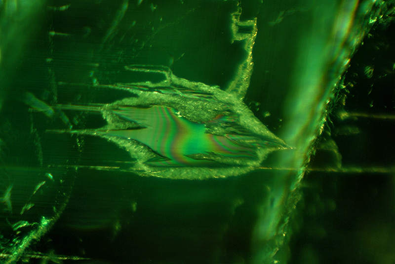 Iridescence on a fluid inclusion lying along a prism face in an emerald from Malysheva, Russia. Specimen courtesy of Tsar Emeralds Corp.; photomicrograph © John I. Koivula/microWorld of Gems